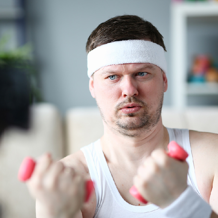 Harry Smith wearing a headband and lifting comically small pink weights /